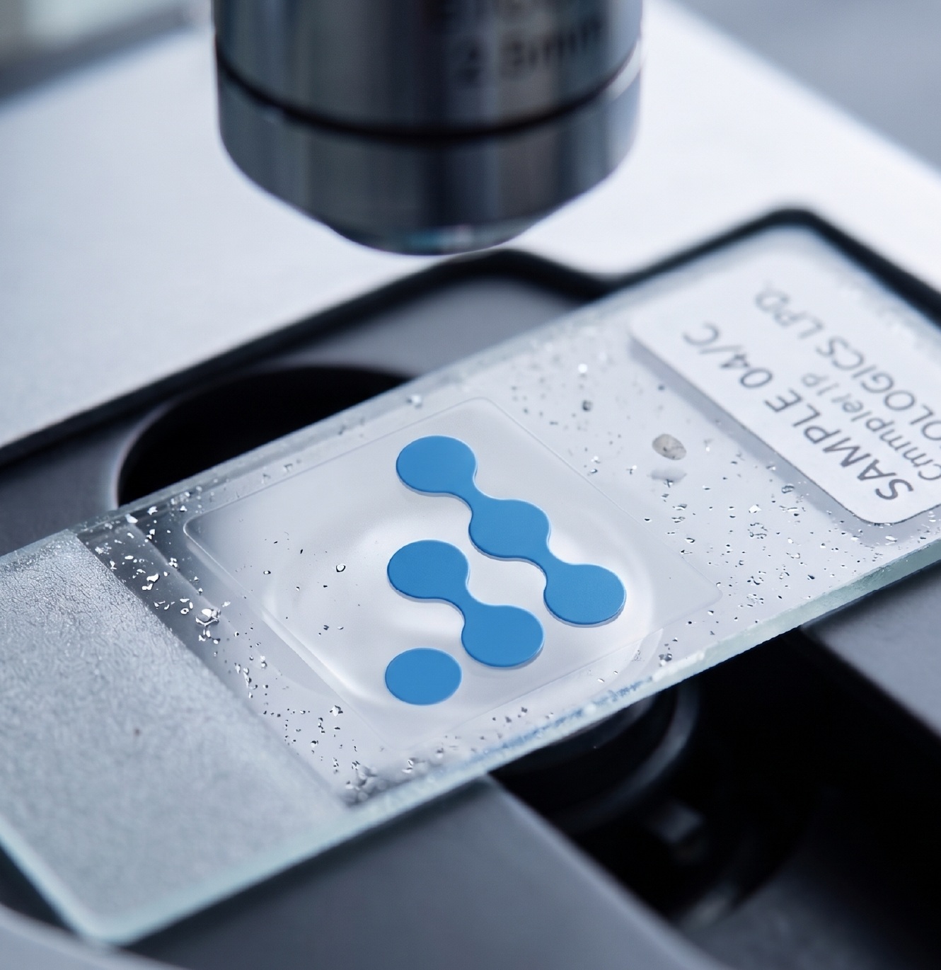 A branded laboratory sample being examined under a microscope